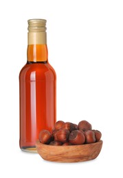Photo of Bottle of delicious syrup for coffee and hazelnuts isolated on white