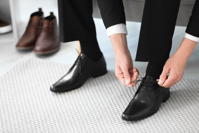 Young man trying on shoes in store