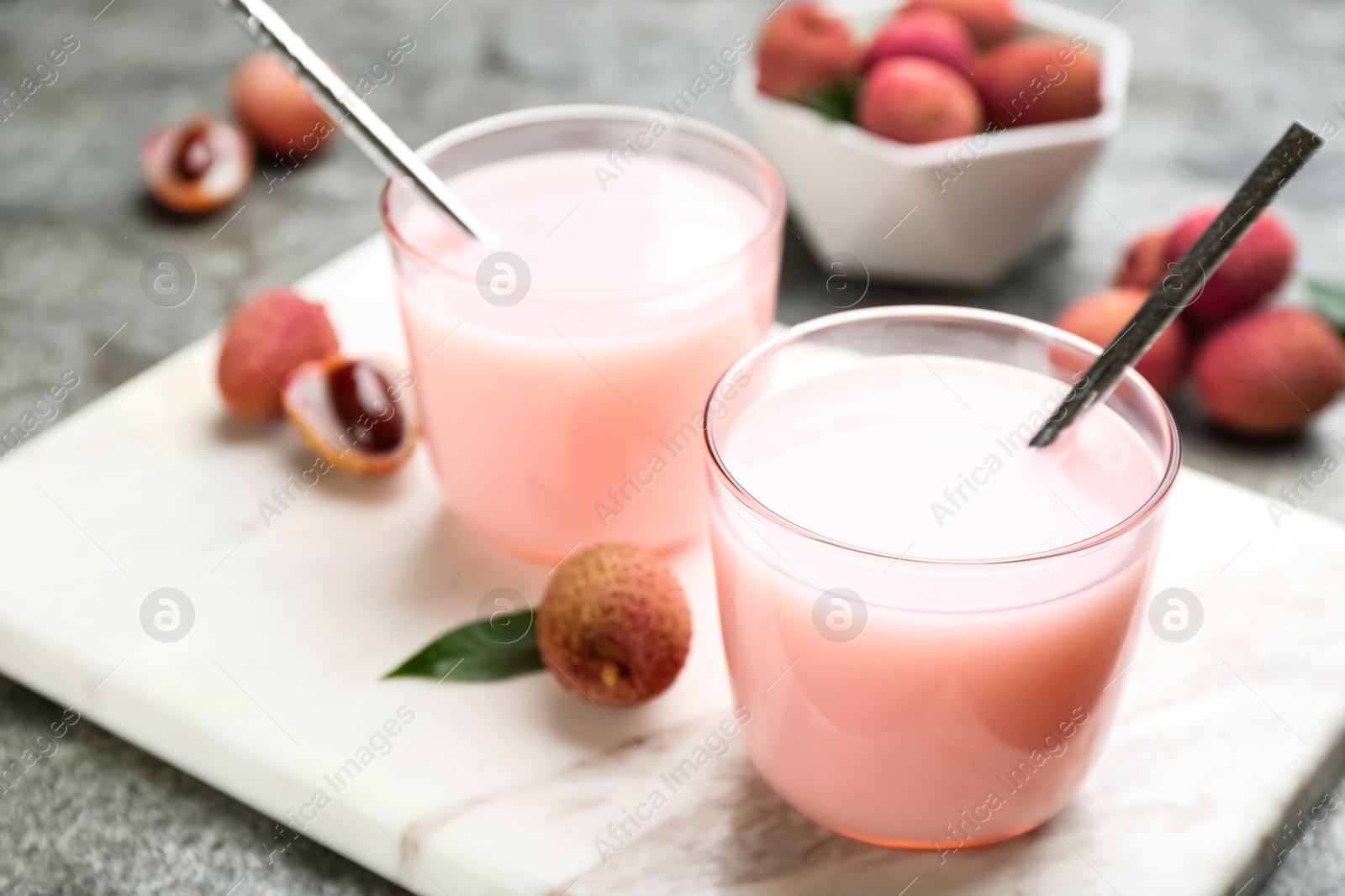 Photo of Delicious lychee cocktails and fresh fruits on white marble board