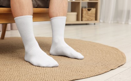 Photo of Man in stylish white socks in armchair indoors, closeup. Space for text