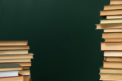 Photo of Many hardcover books near green chalkboard, space for text. Library material