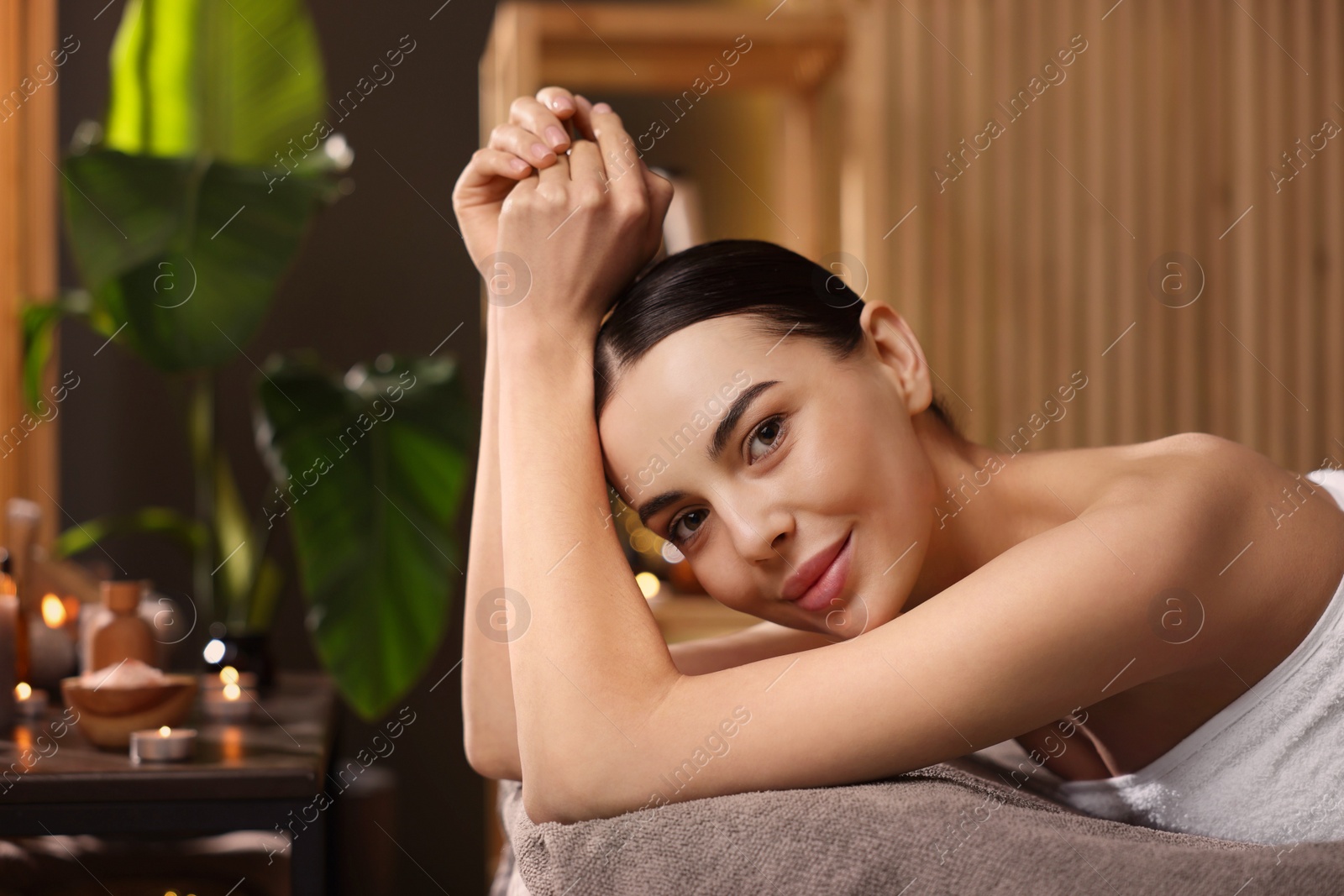 Photo of Spa therapy. Beautiful young woman lying on massage table in salon, space for text