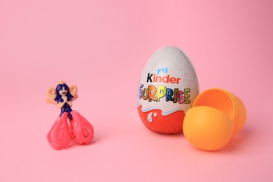 Photo of Slynchev Bryag, Bulgaria - May 25, 2023: Kinder Surprise Egg, plastic capsule and toy on pink background