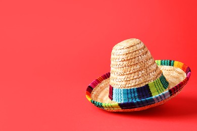 Photo of One Mexican sombrero hat on red background. Space for text
