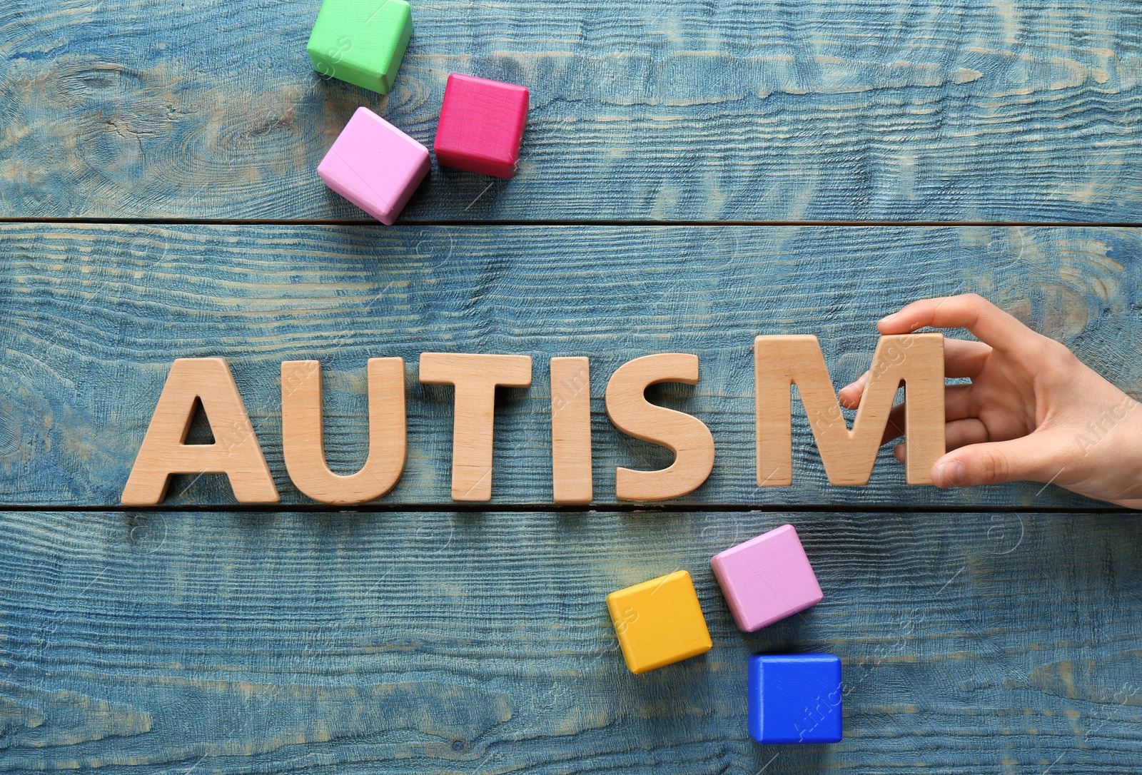 Photo of Woman and word AUTISM made with letters on wooden background