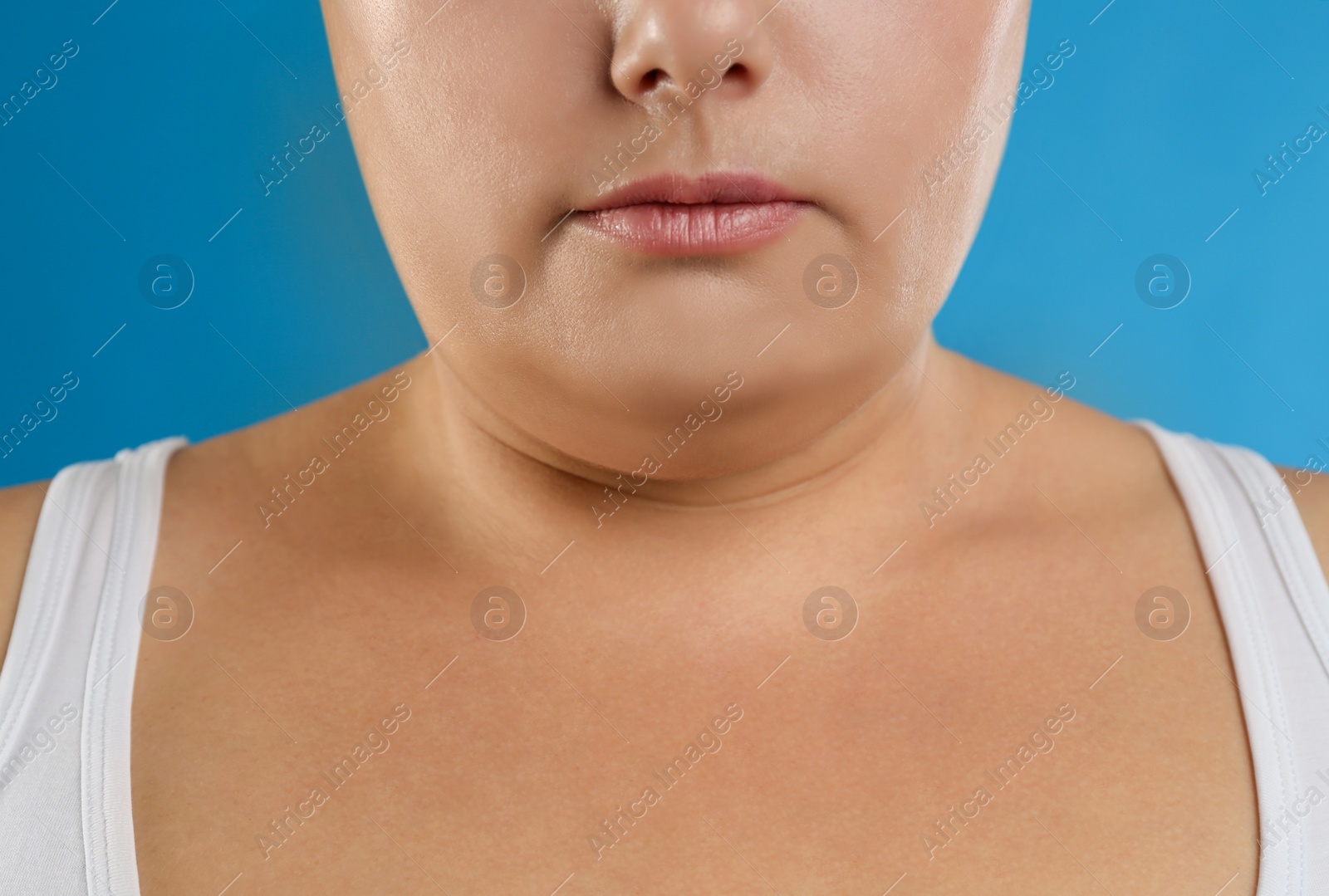 Photo of Woman with double chin on blue background, closeup