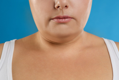 Photo of Woman with double chin on blue background, closeup