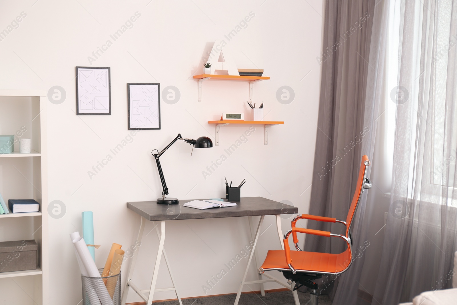 Photo of Stylish room interior with comfortable workplace near window. Design idea