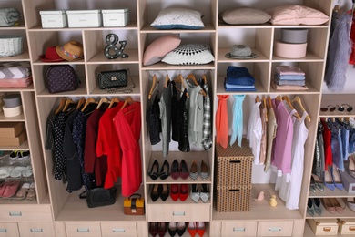 Photo of Large wardrobe with different clothes, home stuff and shoes