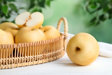 Photo of Cut and whole apple pears on white wooden table against blurred background, closeup