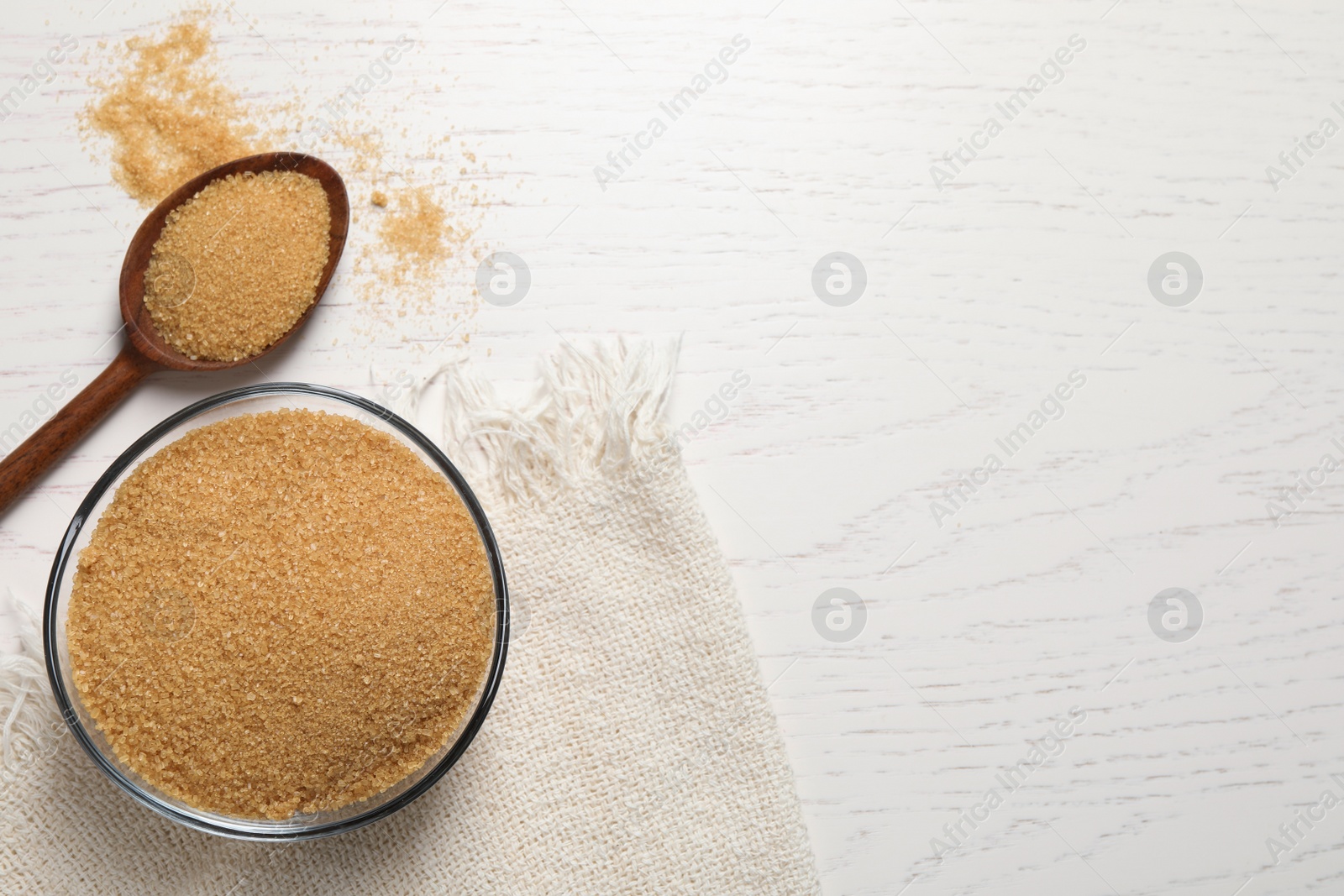 Photo of Brown sugar on white wooden table, flat lay. Space for text