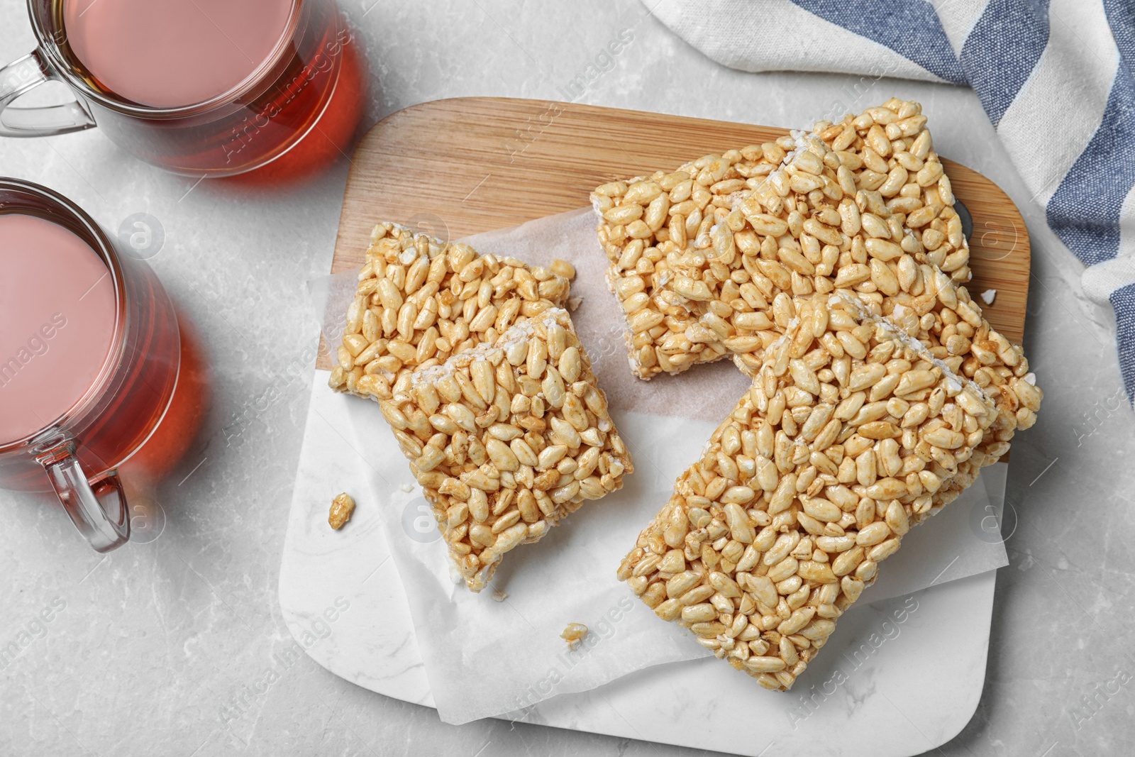 Photo of Delicious rice crispy treats on grey table, flat lay