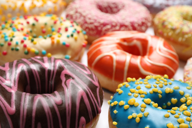 Delicious glazed donuts on white background, closeup