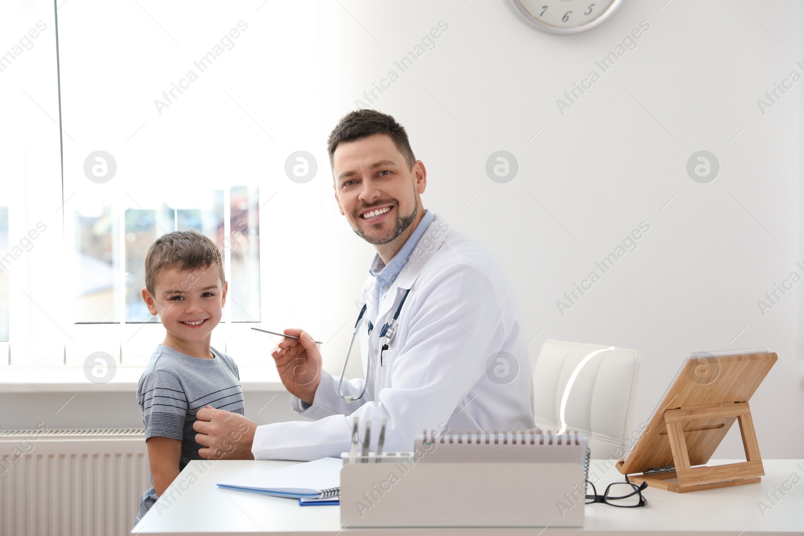 Photo of Children's doctor working with little patient in clinic
