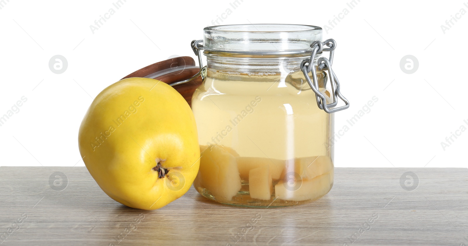 Photo of Delicious quince drink and fresh fruit on wooden table against white background