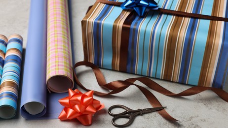 Photo of Beautifully wrapped gift box on grey stone table, closeup