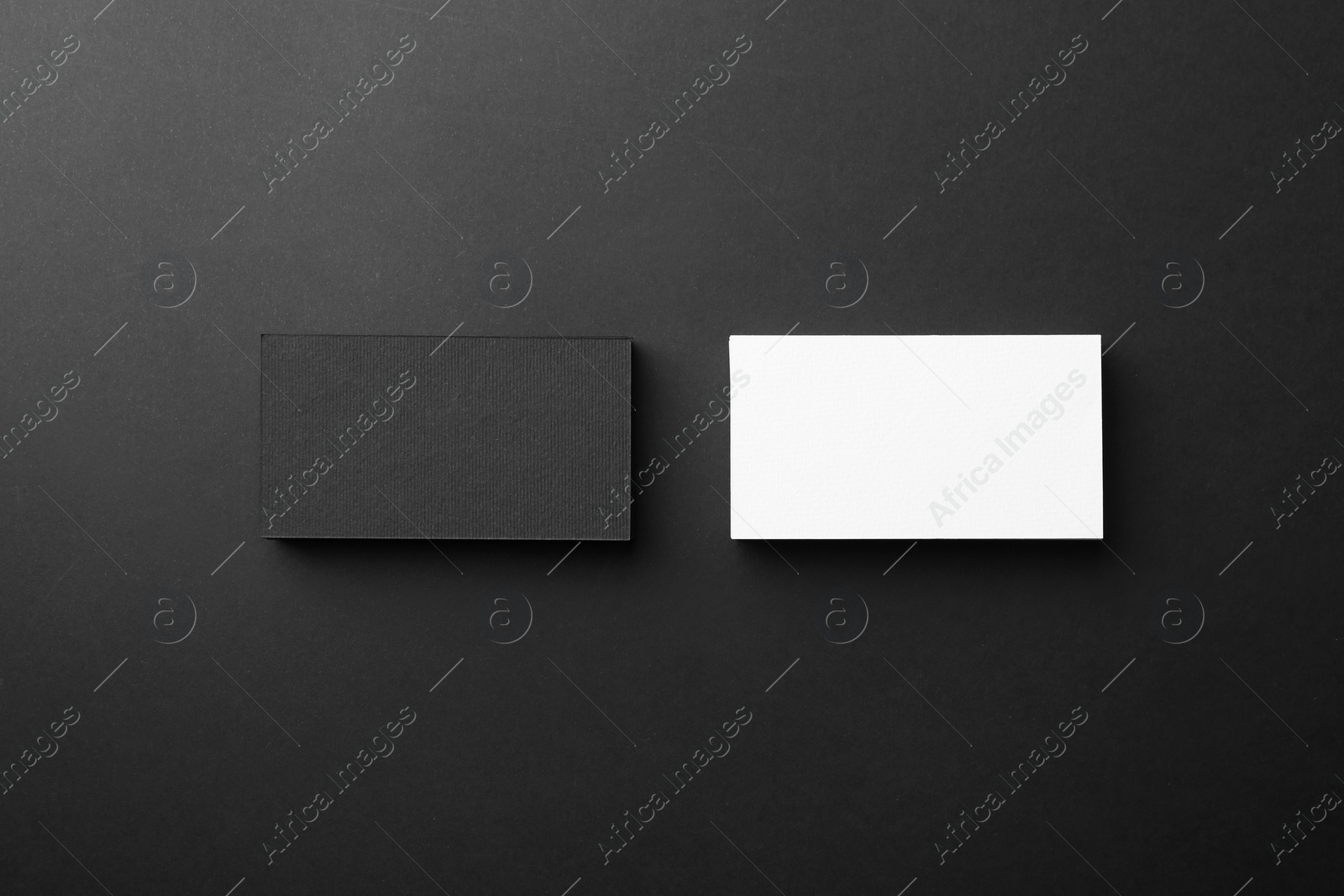 Photo of Blank business cards on black background, flat lay. Mockup for design