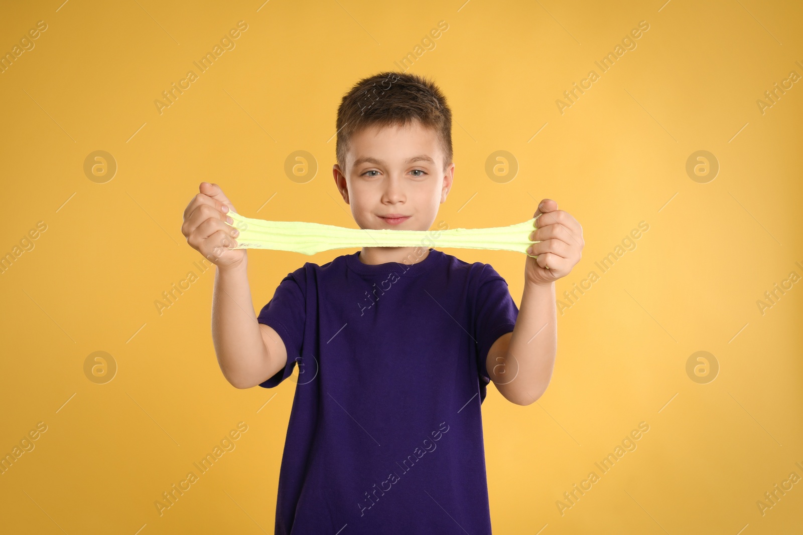 Photo of Little boy with slime on yellow background