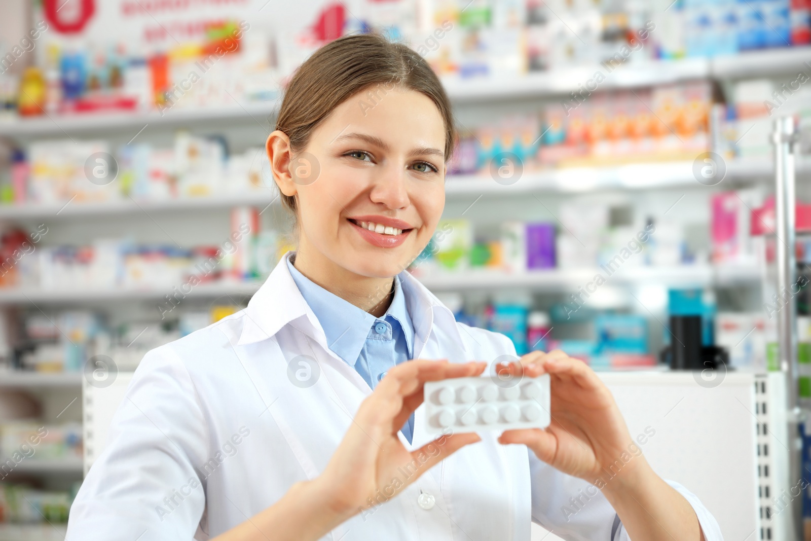 Image of Professional pharmacist with pills in modern drugstore