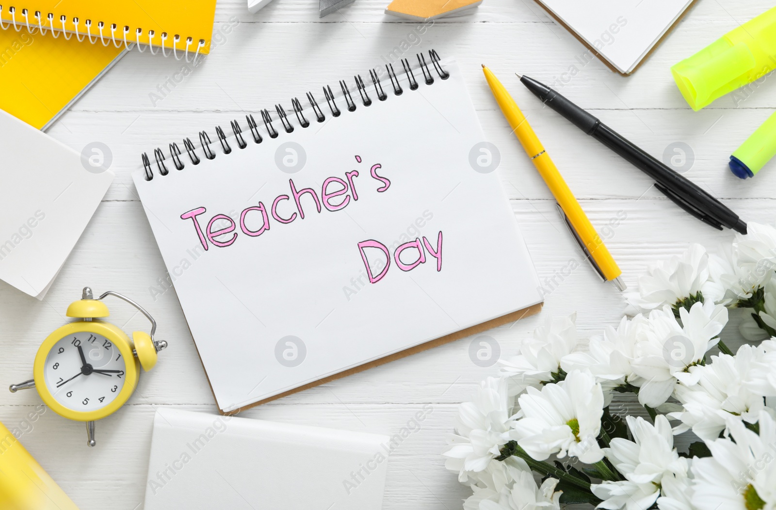 Photo of Flat lay composition with words TEACHER'S DAY, flowers and stationery on white wooden background