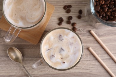 Photo of Fresh iced coffee and beans on wooden table, flat lay