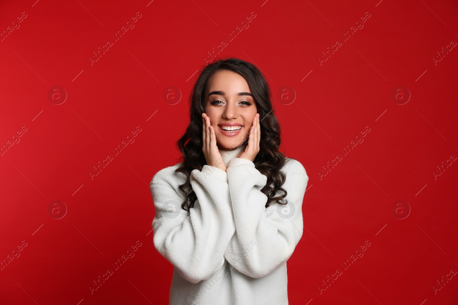 Photo of Beautiful young woman wearing warm sweater on red background. Christmas party