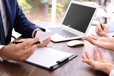 Photo of Lawyer working with clients at table in office, focus on hands