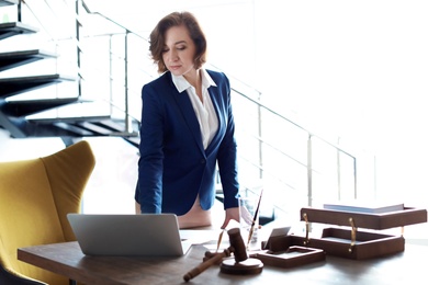 Female lawyer standing near table in office