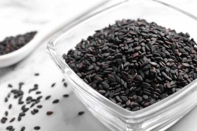 Photo of Black sesame seeds on white table, closeup
