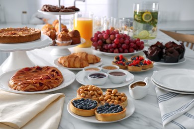 Photo of Variety of snacks on white marble table in buffet style indoors