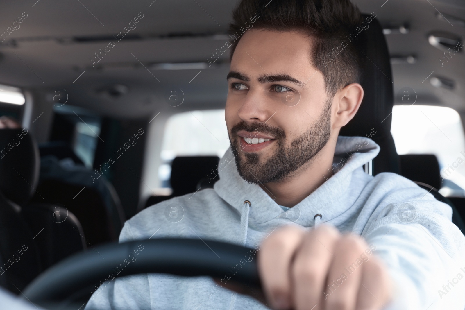 Photo of Handsome young man driving his modern car