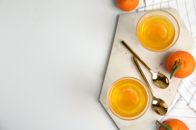 Delicious tangerine jelly and fresh fruits on white table, flat lay. Space for text
