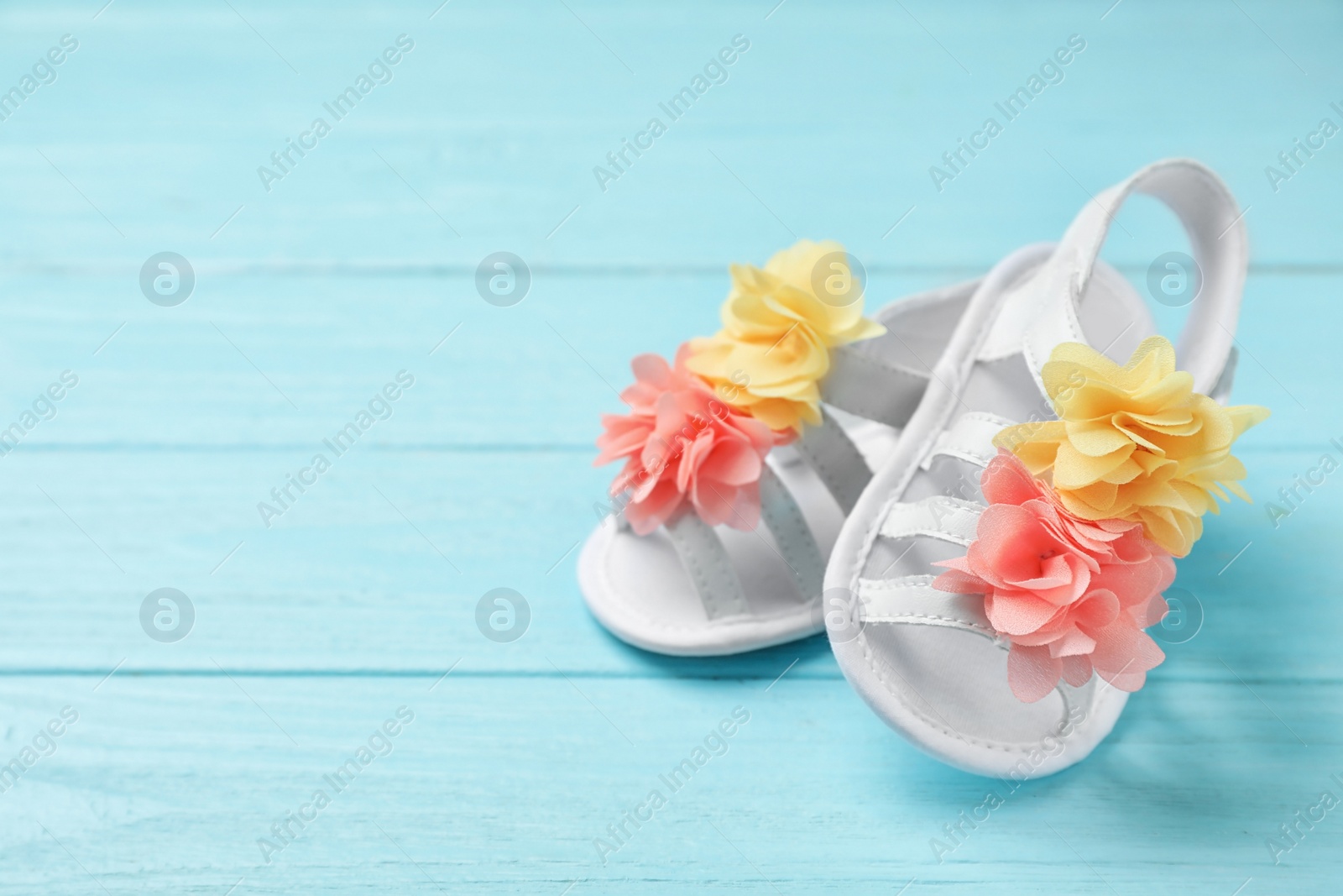 Photo of Pair of cute baby sandals on wooden background