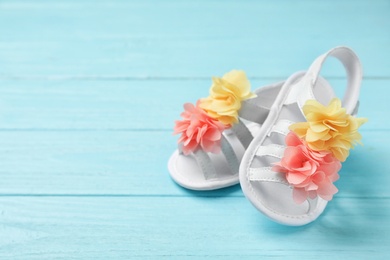 Photo of Pair of cute baby sandals on wooden background