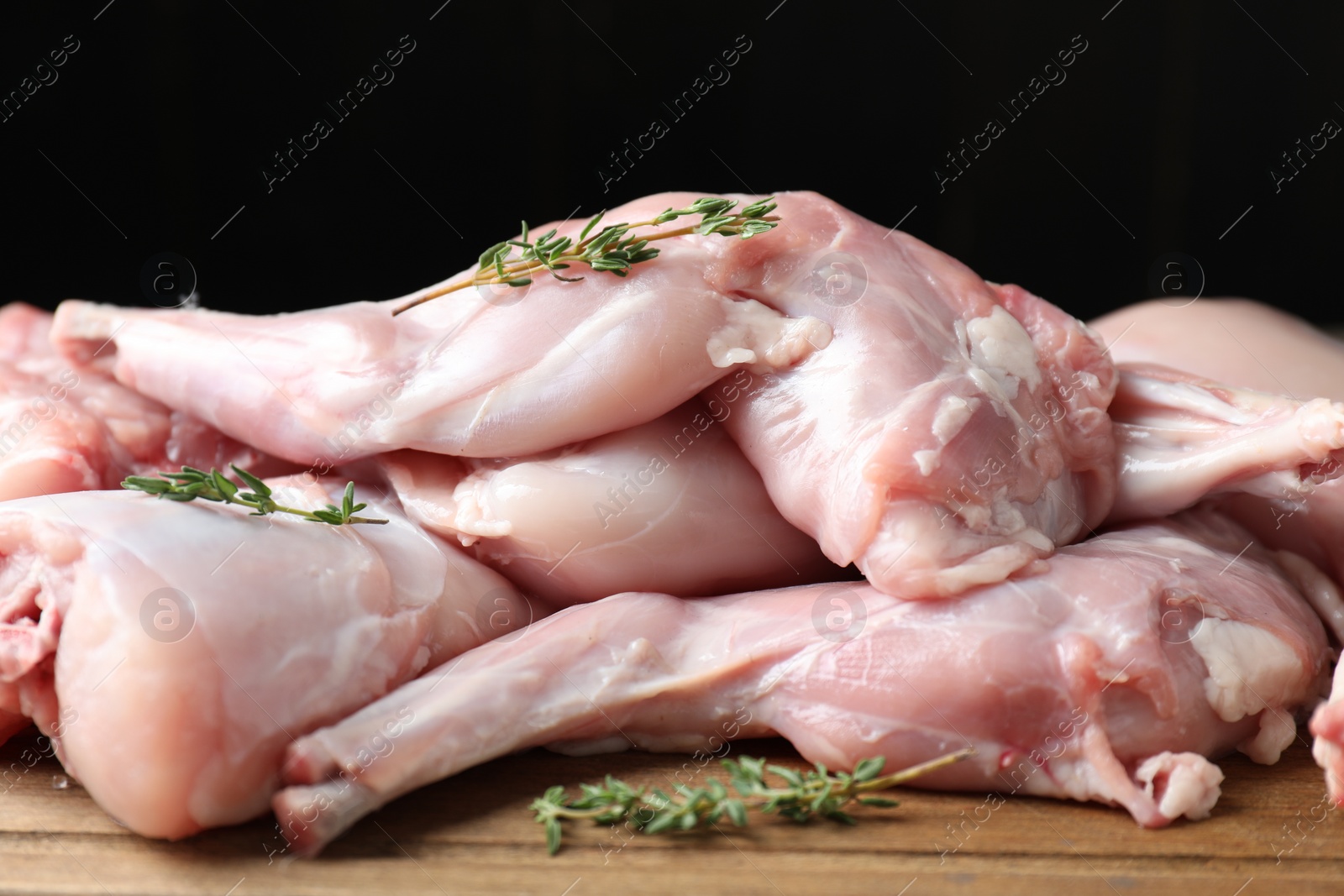 Photo of Fresh raw rabbit meat and spices on wooden board, closeup