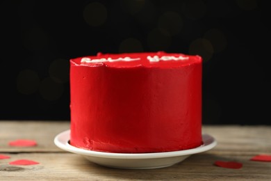 Photo of Bento cake covered with red cream on wooden table. St. Valentine's day surprise