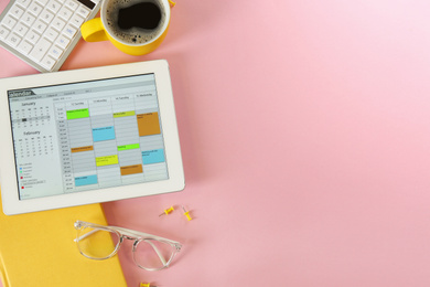 Photo of Modern tablet with calendar app on pink background, flat lay. Space for text