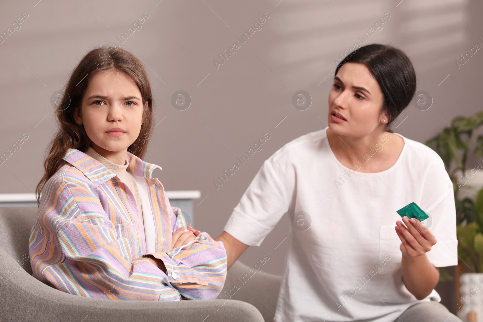 Photo of Mother talking with her teenage daughter about contraception at home. Sex education concept