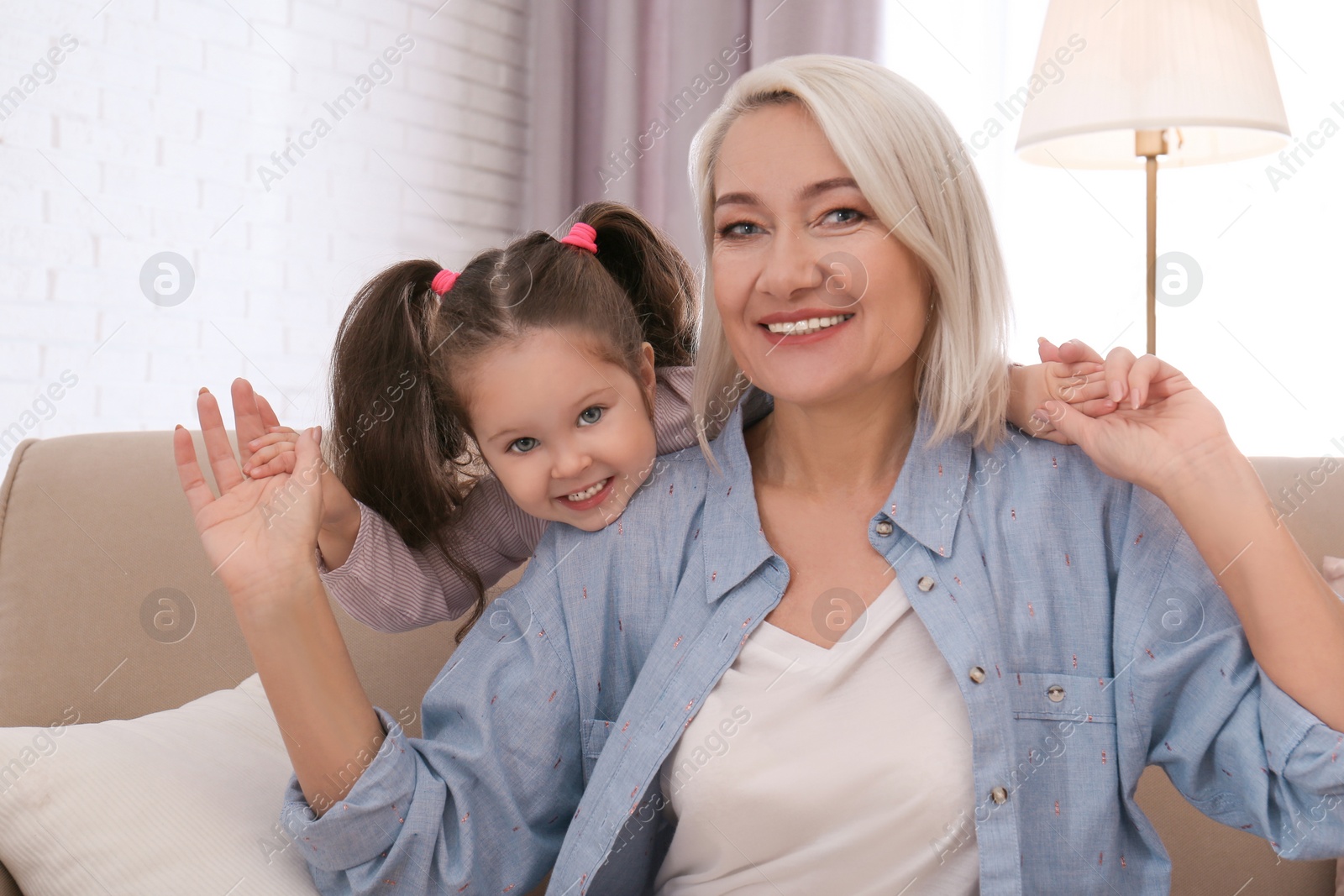 Photo of Happy granddaughter and grandmother together at home