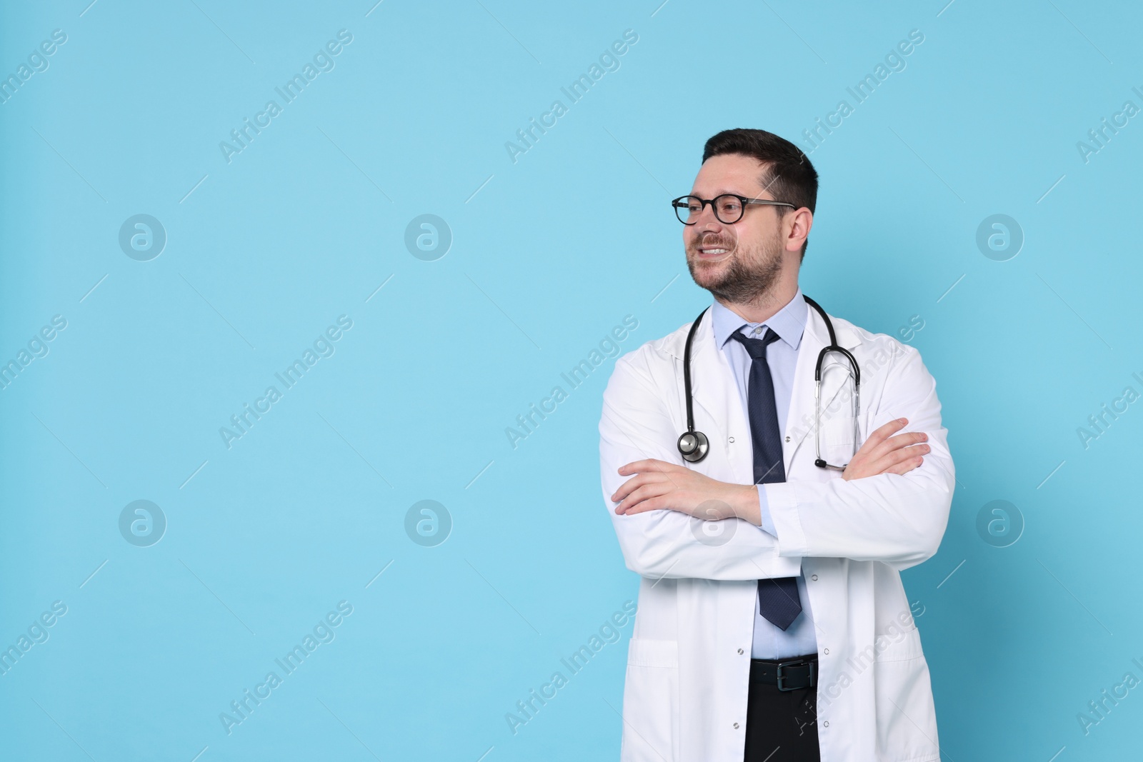 Photo of Smiling doctor on light blue background, space for text