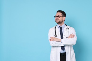 Smiling doctor on light blue background, space for text