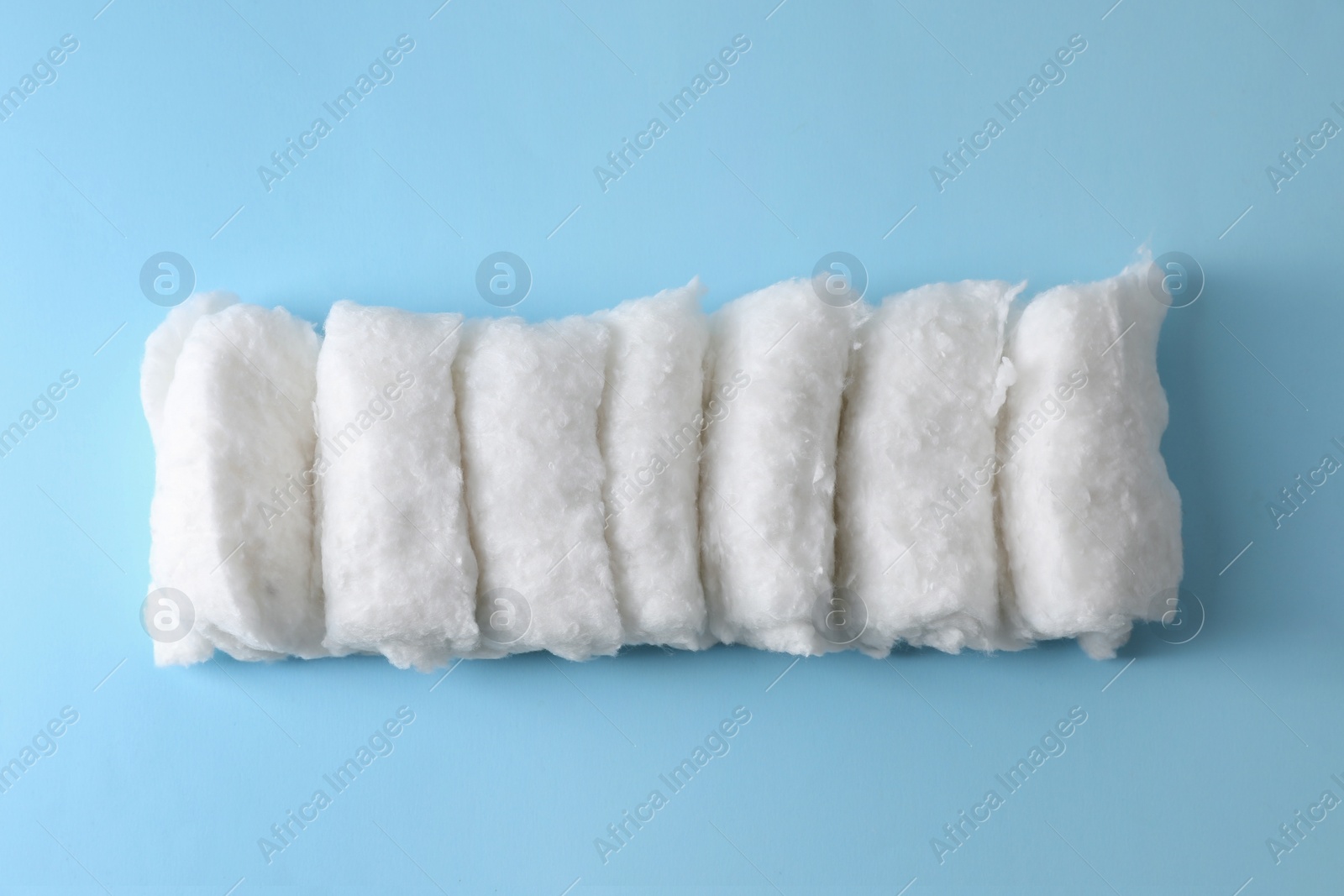 Photo of Soft clean cotton on light blue background, top view