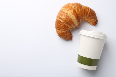 Photo of Delicious fresh croissant and paper cup with coffee on white background, flat lay. Space for text