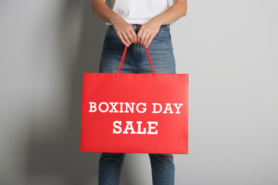 Image of Woman holding red shopping bag with text Boxing Day Sale, closeup