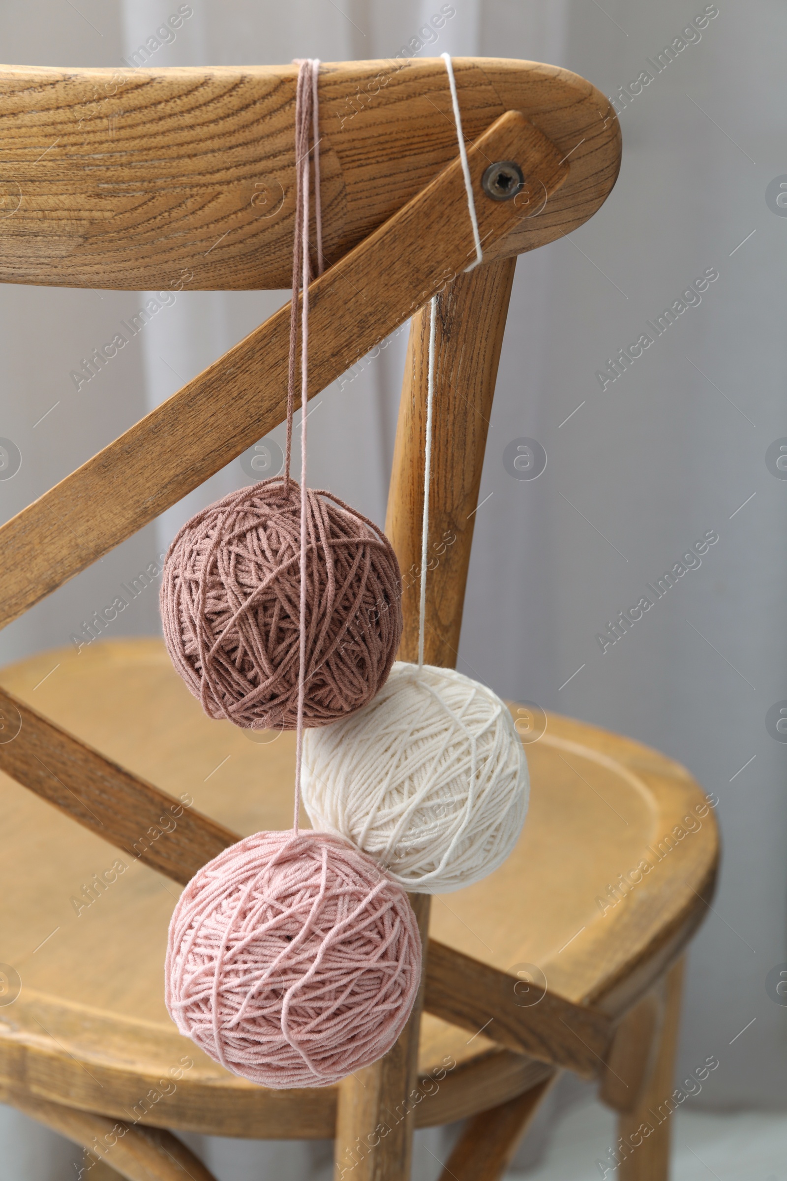 Photo of Soft woolen yarns hanging on chair indoors