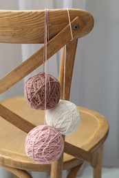 Photo of Soft woolen yarns hanging on chair indoors