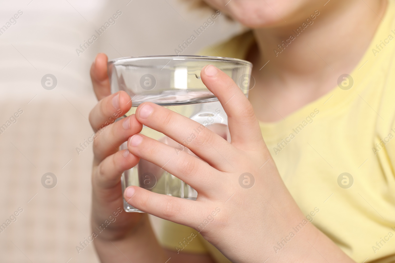 Photo of Little boy holding glass of fresh water, closeup