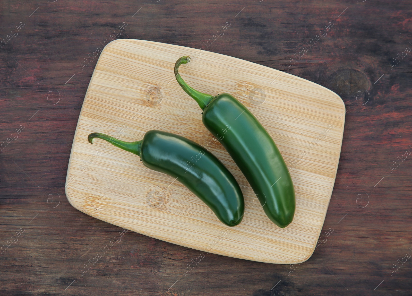 Photo of Fresh green jalapeno peppers on wooden table, top view