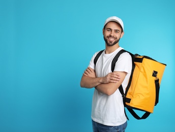 Young courier with thermo bag on color background, space for text. Food delivery service