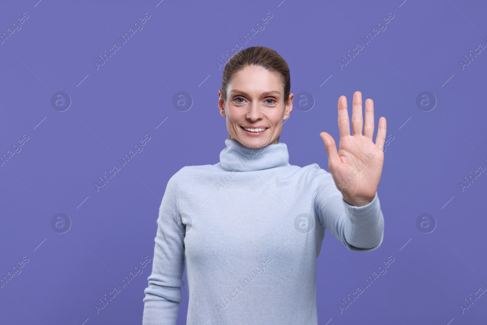 Photo of Woman giving high five on purple background